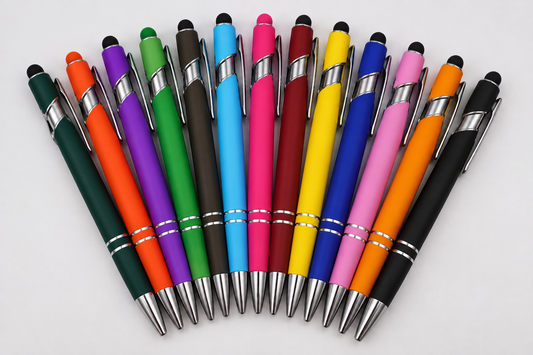 A set of twelve retractable ballpoint pens in assorted colors, arranged in a fan shape on a plain white background. Each pen features a smooth barrel, a silver metal clip, silver metallic bands, and a silver tip.