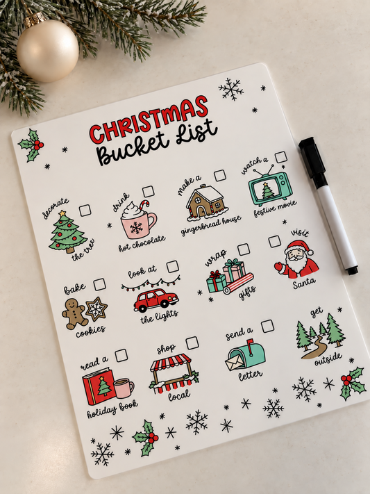 Christmas bucket list acrylic dry-erase board without a name, with illustrated holiday activity checkboxes, a marker and neutral Christmas decor.