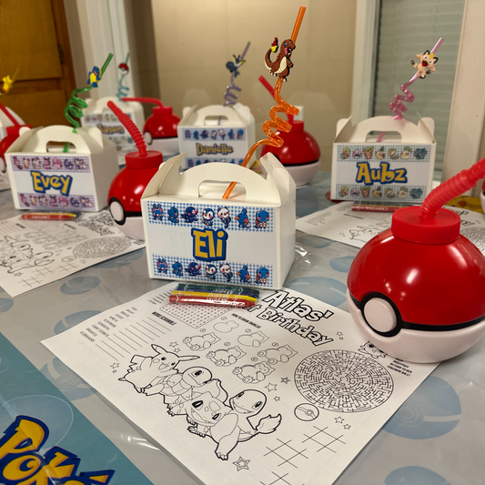 Personalized white gable favor boxes displayed on a birthday party table
