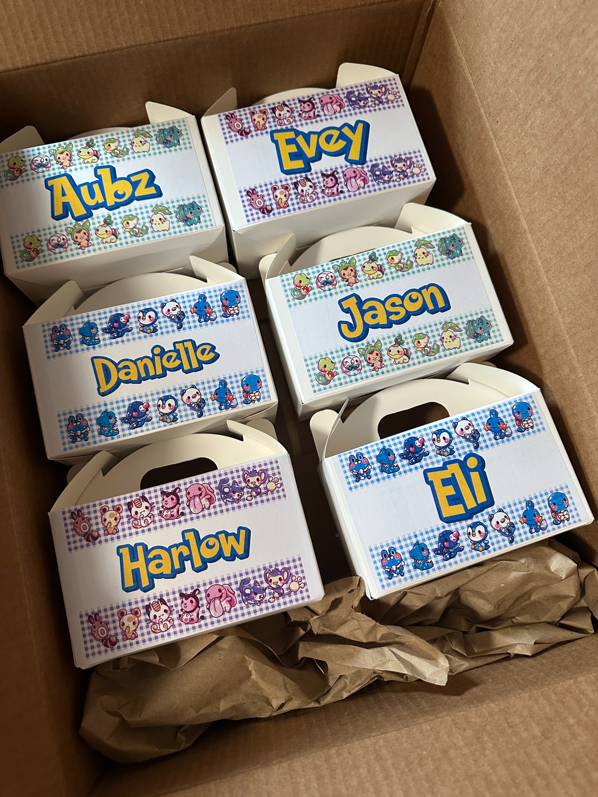 White gable party favor boxes with custom names and colorful front designs
