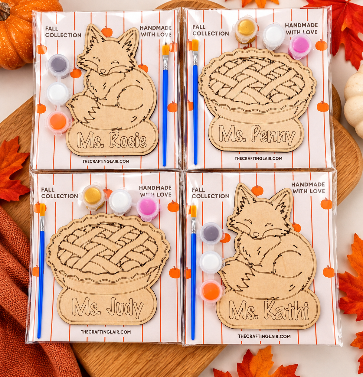Four packaged wooden name plaques shaped like pies, each with a different fox or pie illustration and the names Ms. Rosie, Ms.