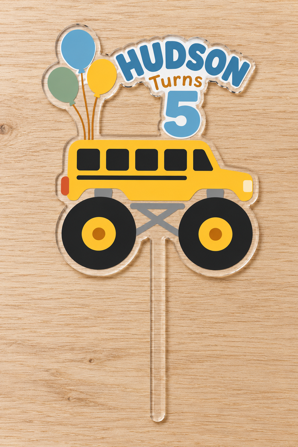 Personalized yellow school bus monster truck birthday cake topper with custom name and age on clear acrylic