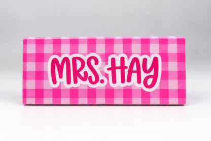 Front view of a pink checkered dry erase eraser with custom teacher name