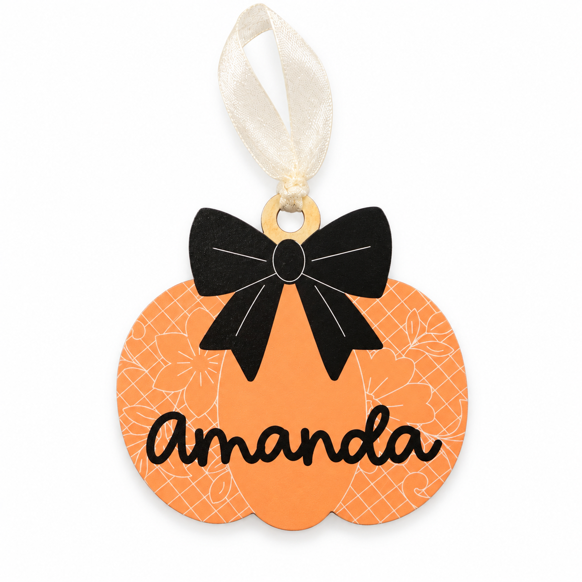 Orange pumpkin name tag with white floral pattern, black printed bow, Amanda lettering and cream ribbon, front view.