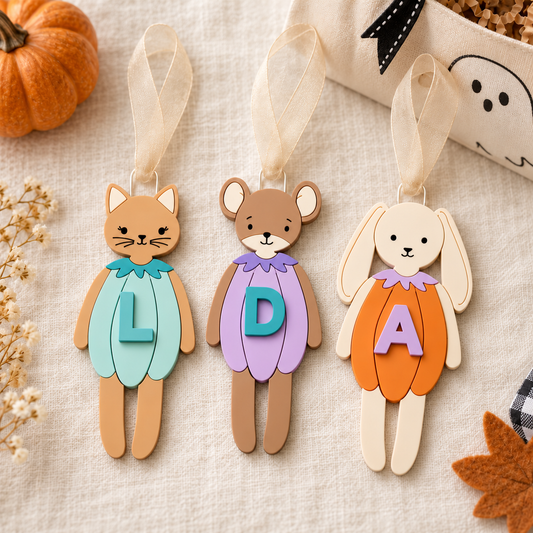 Personalized pumpkin Boo Bag Tags: mint cat with L, lavender mouse with D, orange bunny with A and beige sheer ribbons