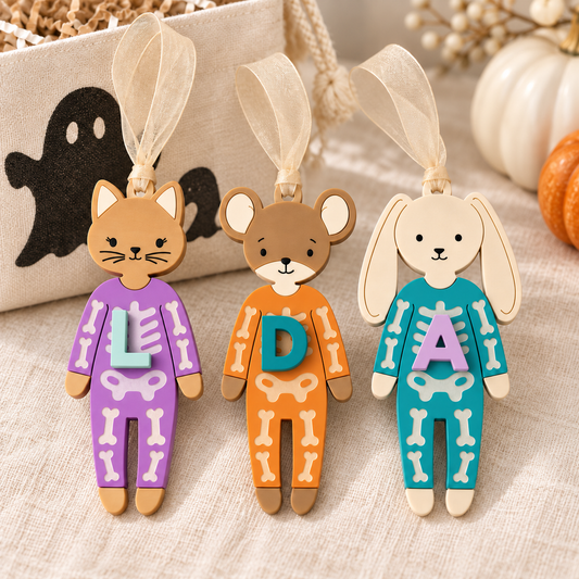 Personalized skeleton Boo Bag Tags: purple cat with L, orange mouse with D, teal bunny with A and beige sheer ribbons