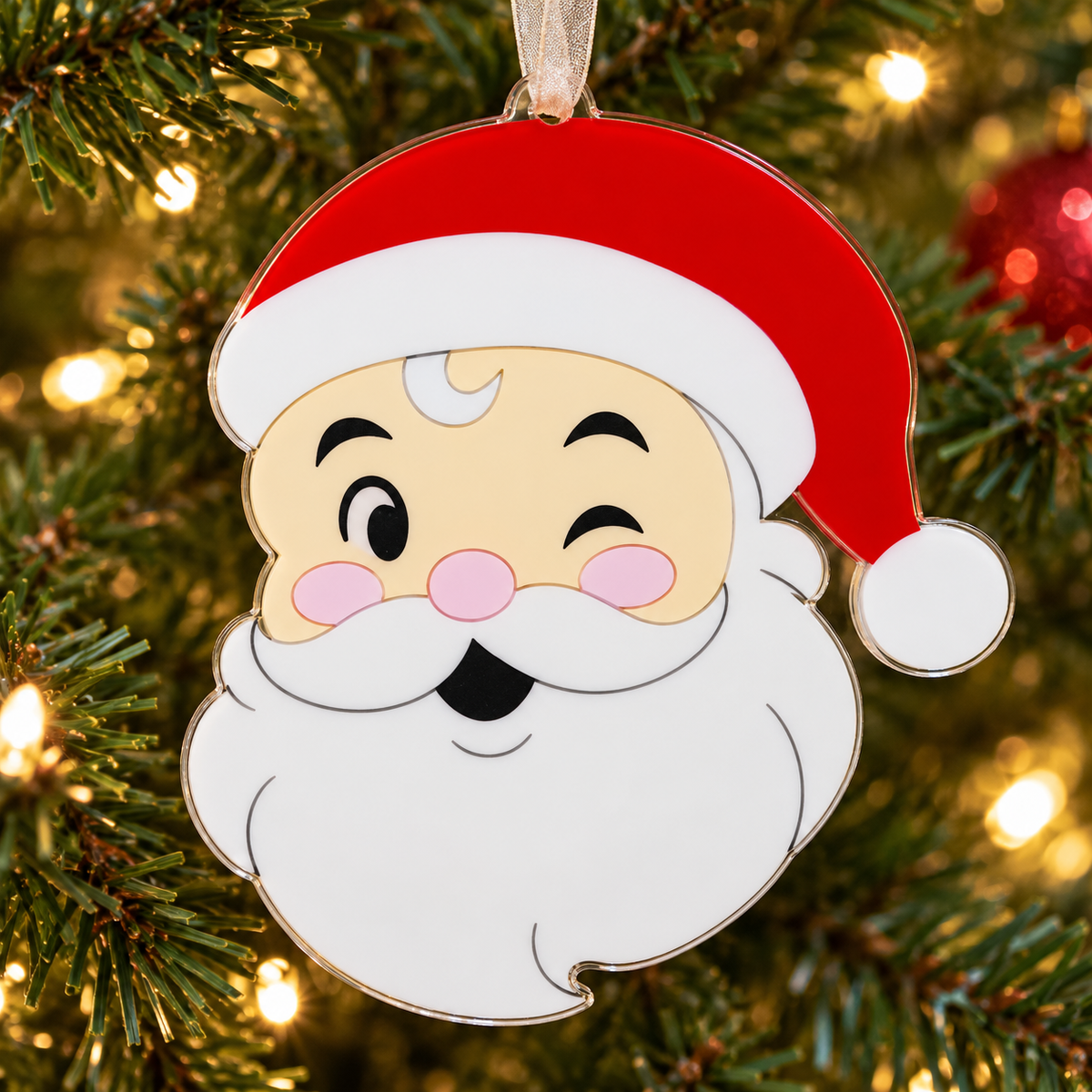santa UV printed acrylic Christmas ornament hanging on a Christmas tree, with sheer beige ribbon.