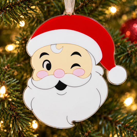 santa UV printed acrylic Christmas ornament hanging on a Christmas tree, with sheer beige ribbon.